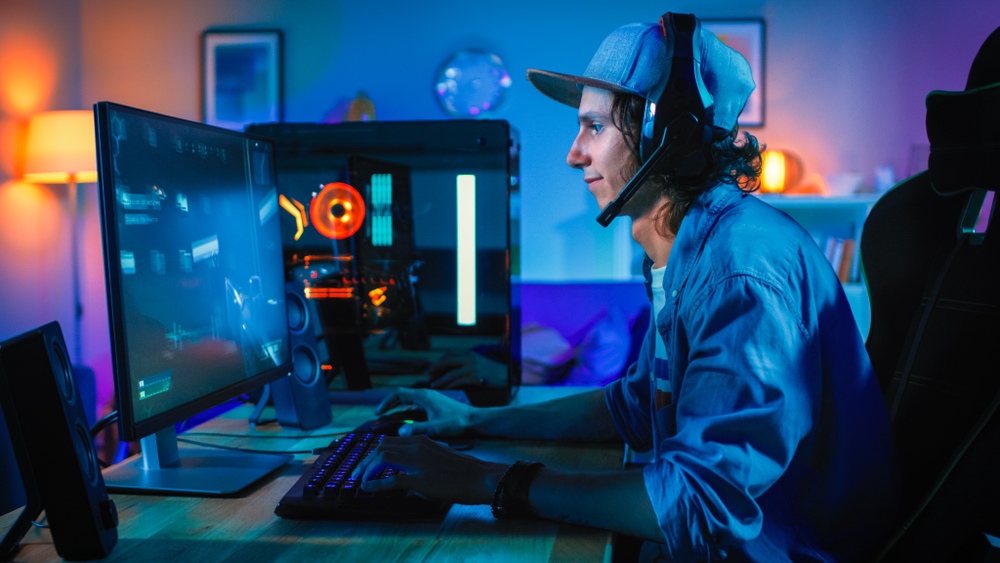 man playing video games on a desktop computer